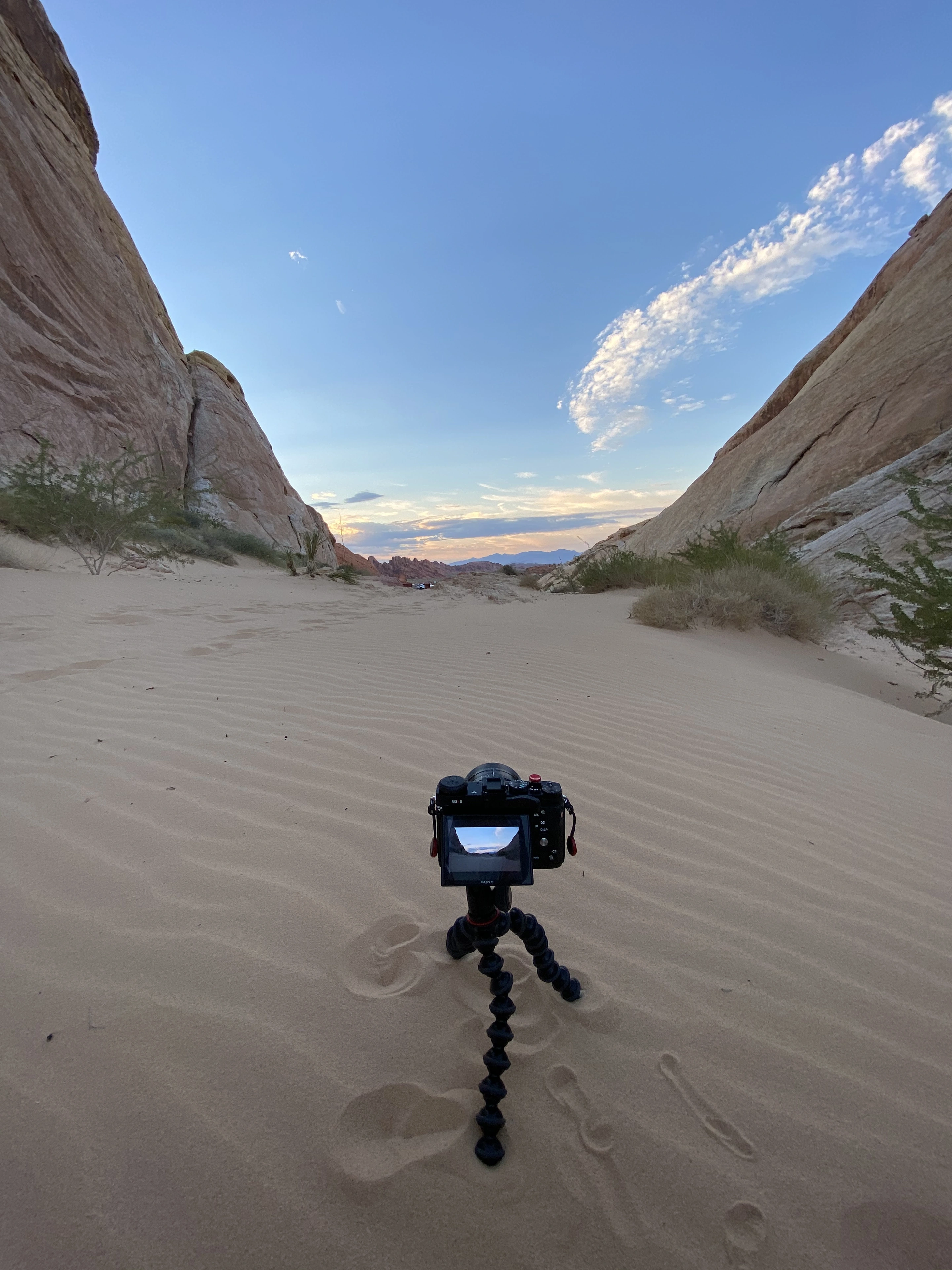 A camera on a small tripod framing a passage through desert sandstone