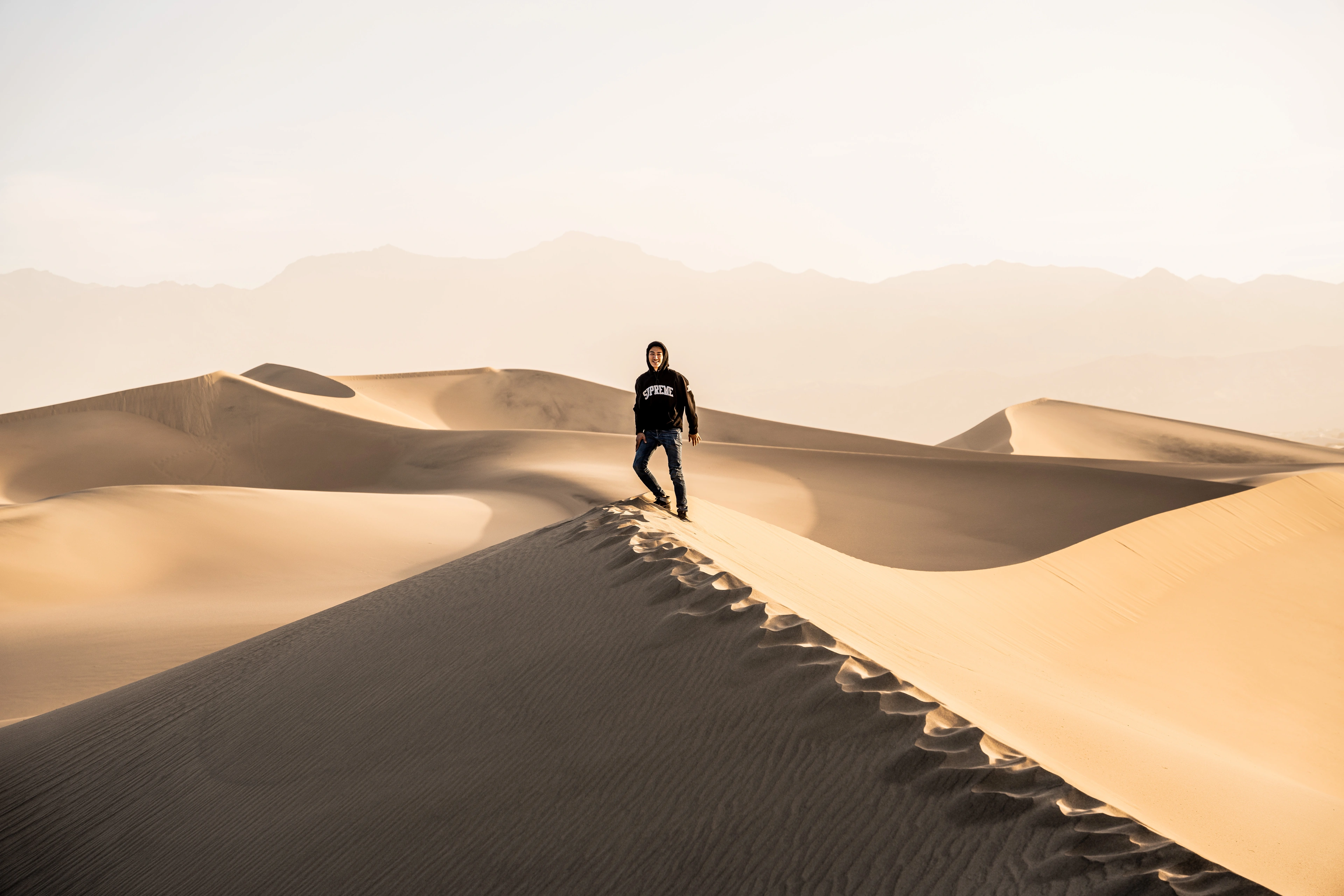 David walking along the ridge of a sand dune