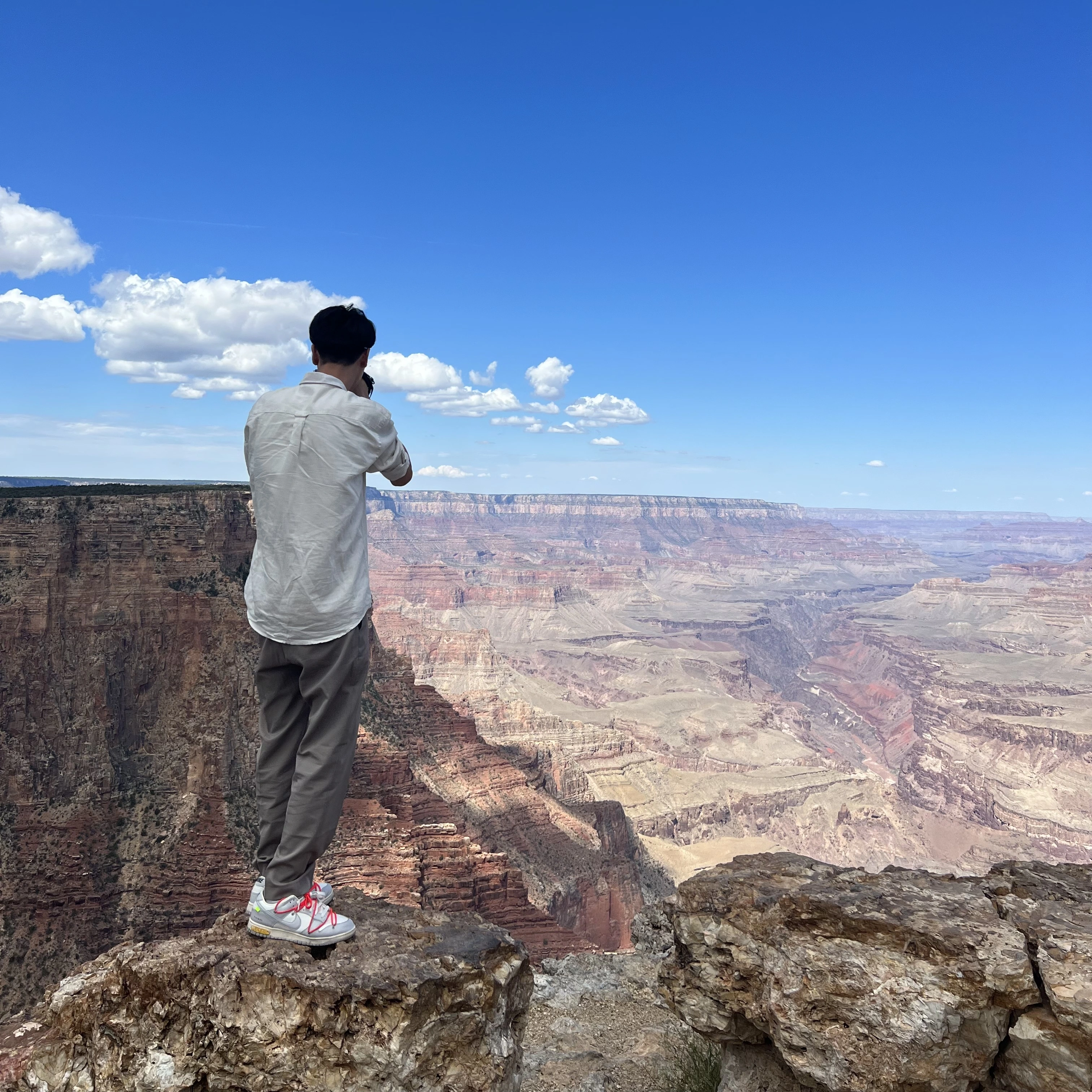 David photographing the Grand Canyon beneath a vivid blue sky