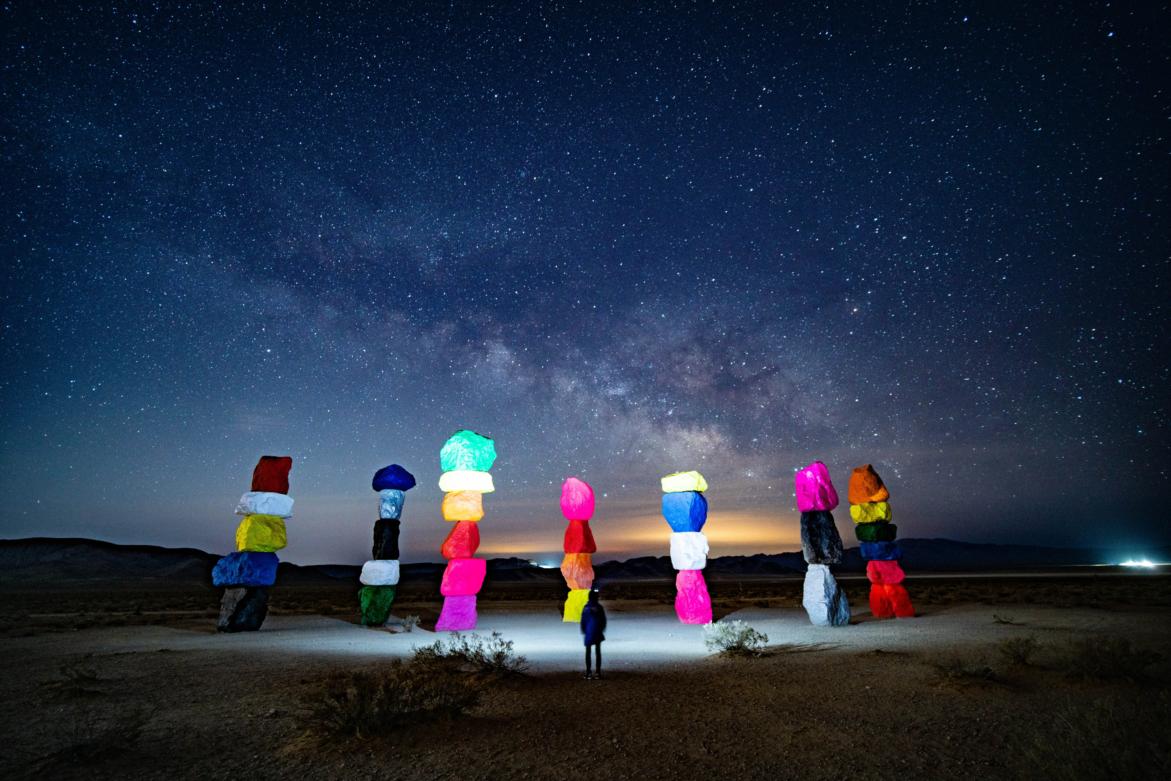 David standing beneath the Milky Way among illuminated painted stone towers