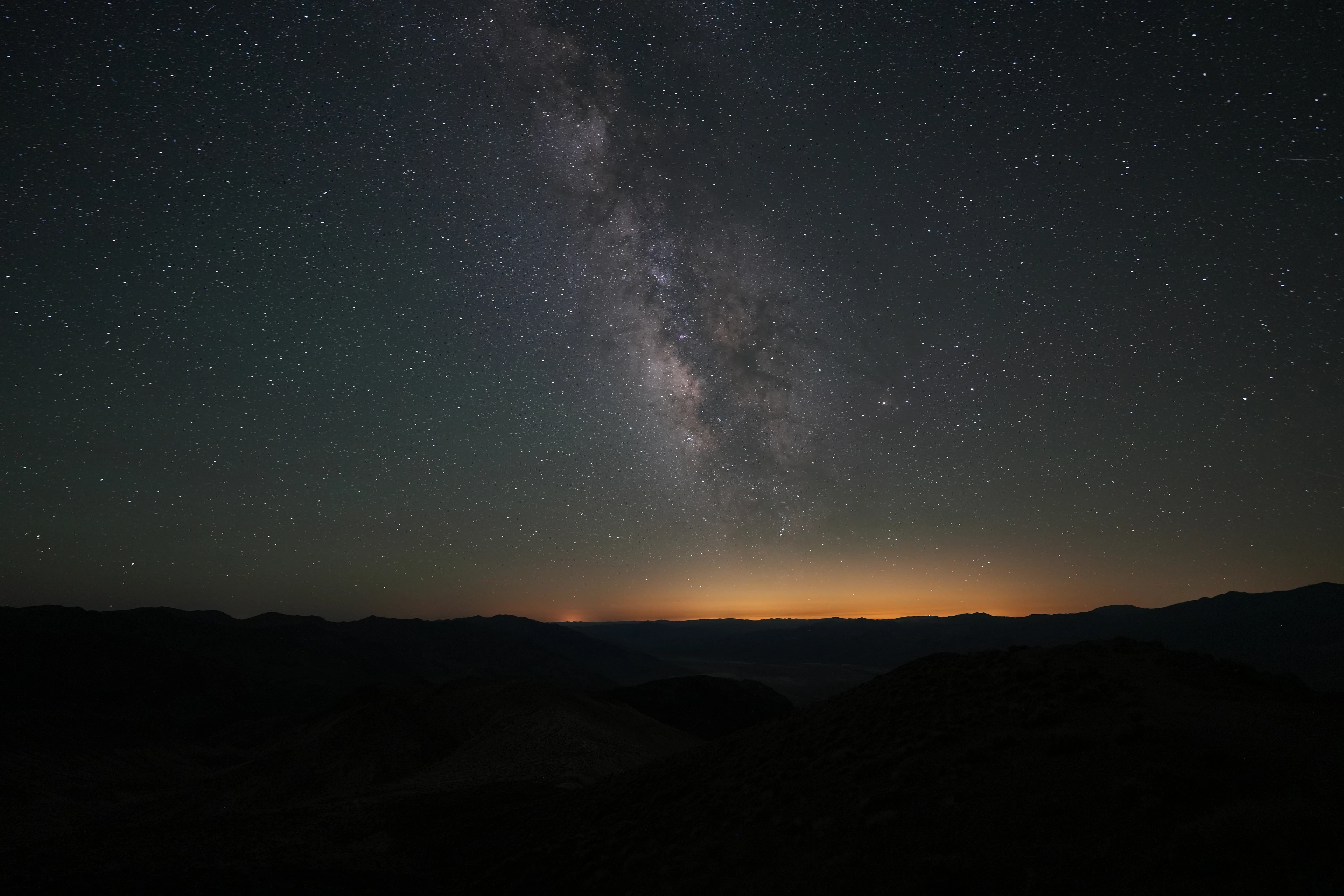 The Milky Way above a dark mountain horizon in Death Valley