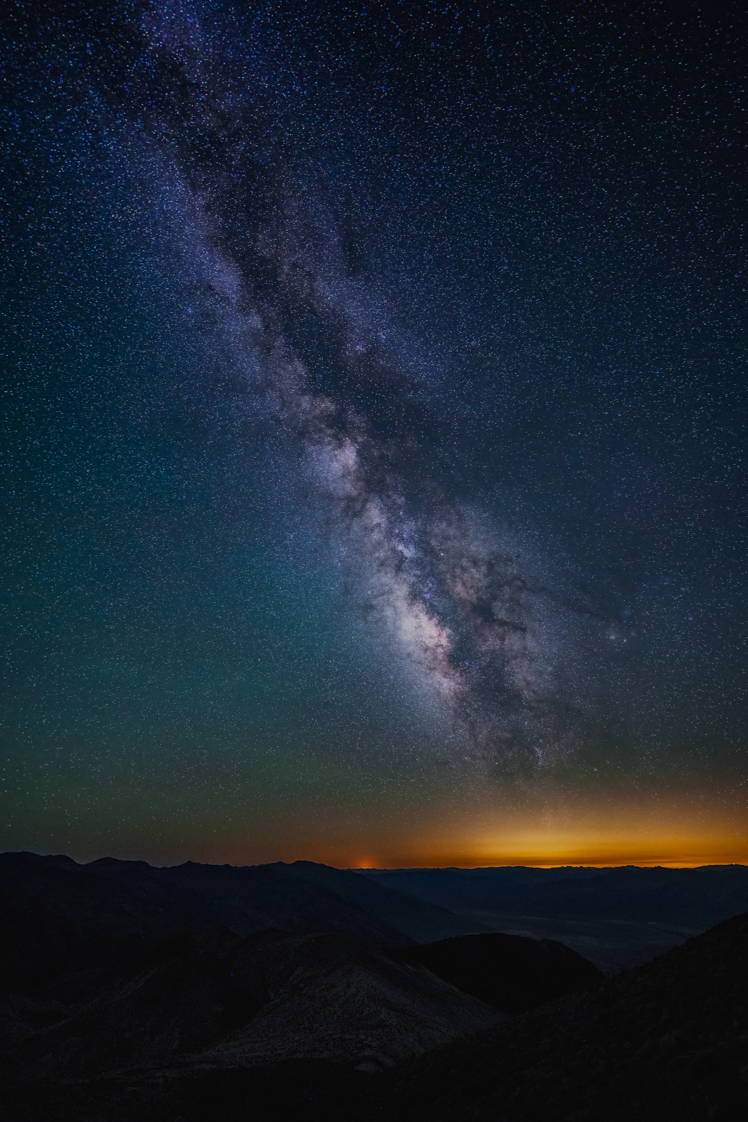 A vertical Milky Way above the dark ridges of Death Valley