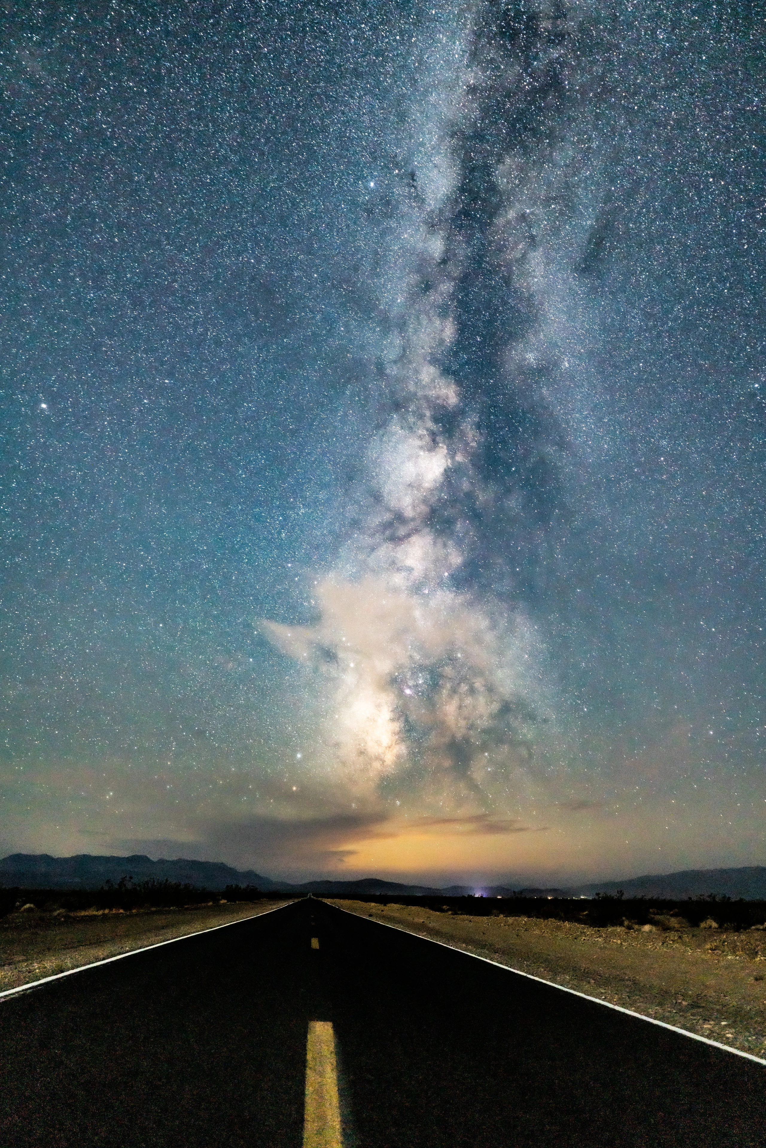 The Milky Way rising vertically above a distant desert horizon
