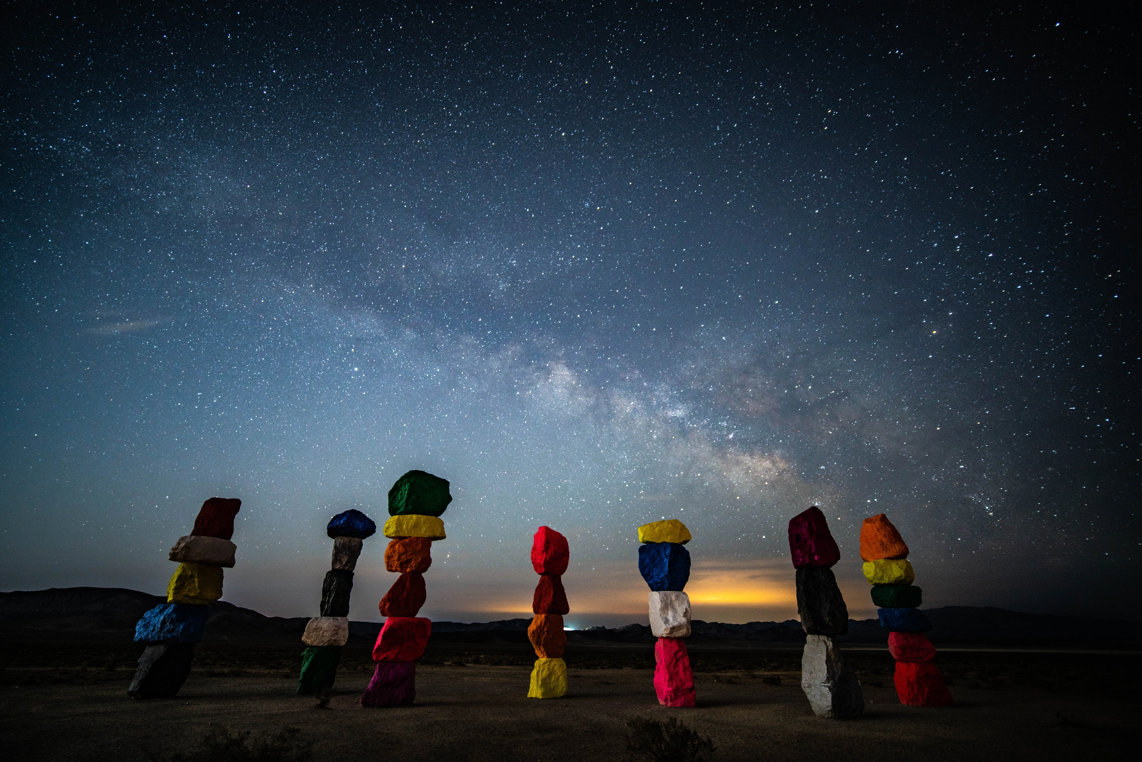 Small colorful figures lined up beneath the Milky Way