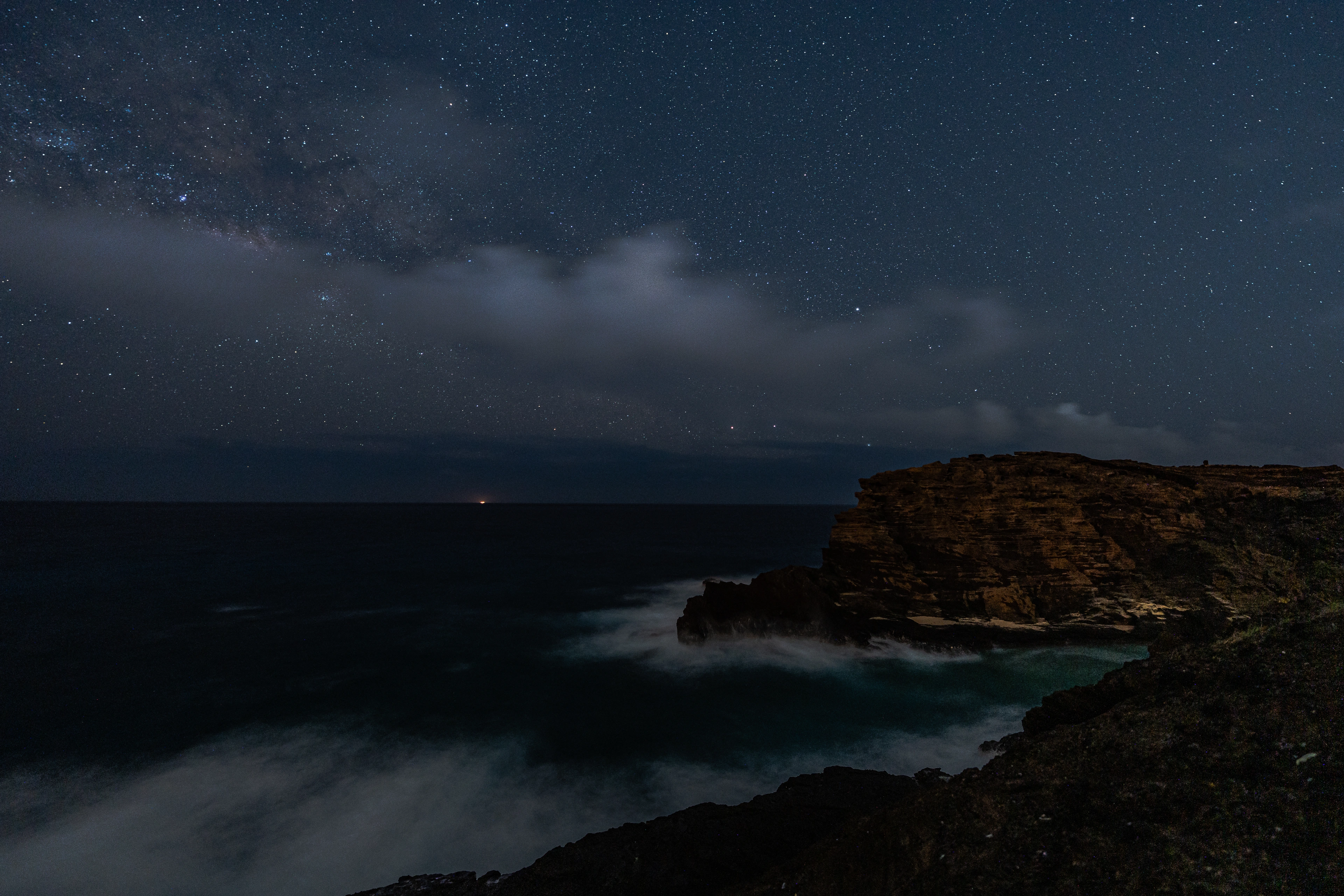 A dark coastal rock beneath stars on East Oahu