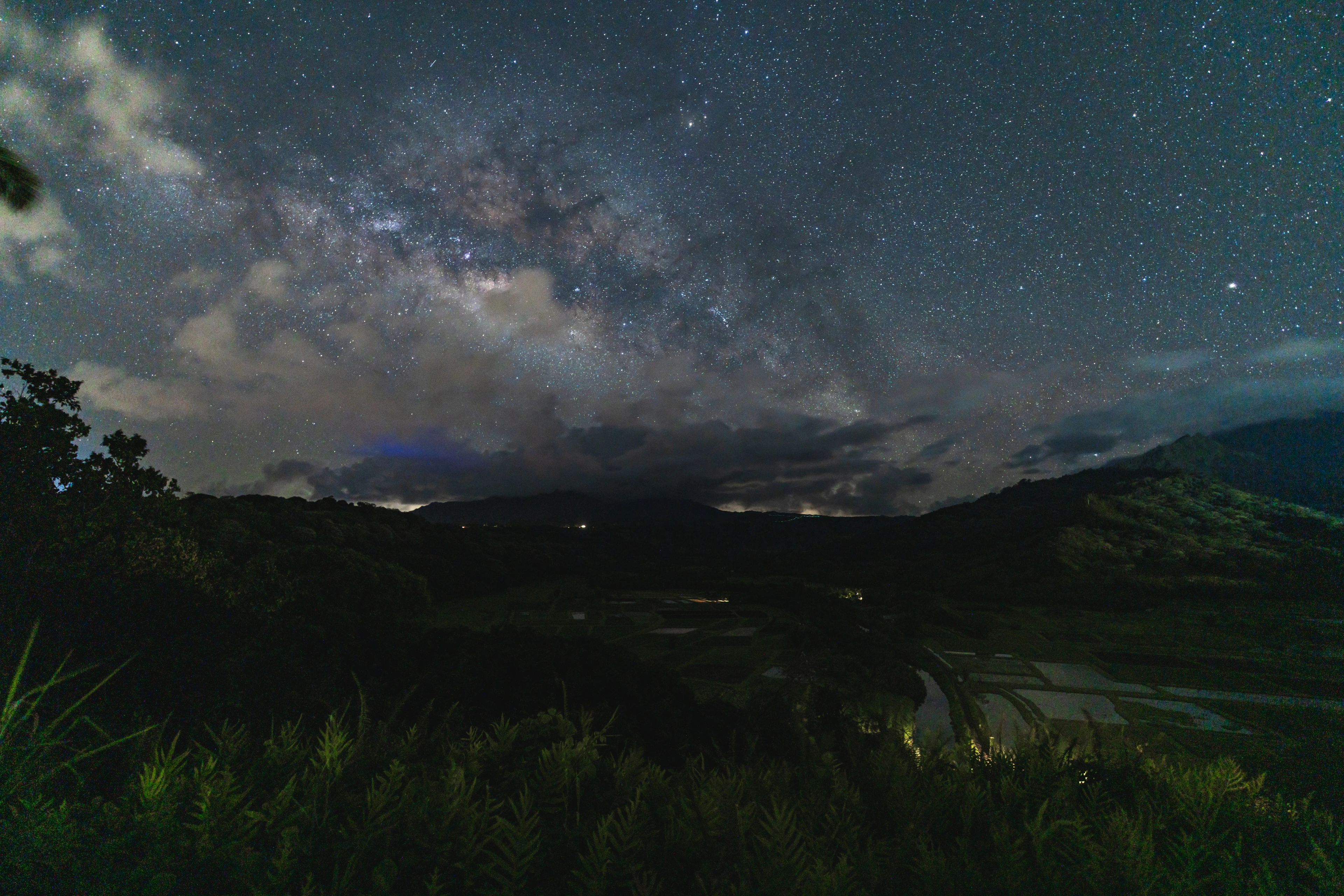 The Milky Way stretching above the dark fields of Hanalei Valley