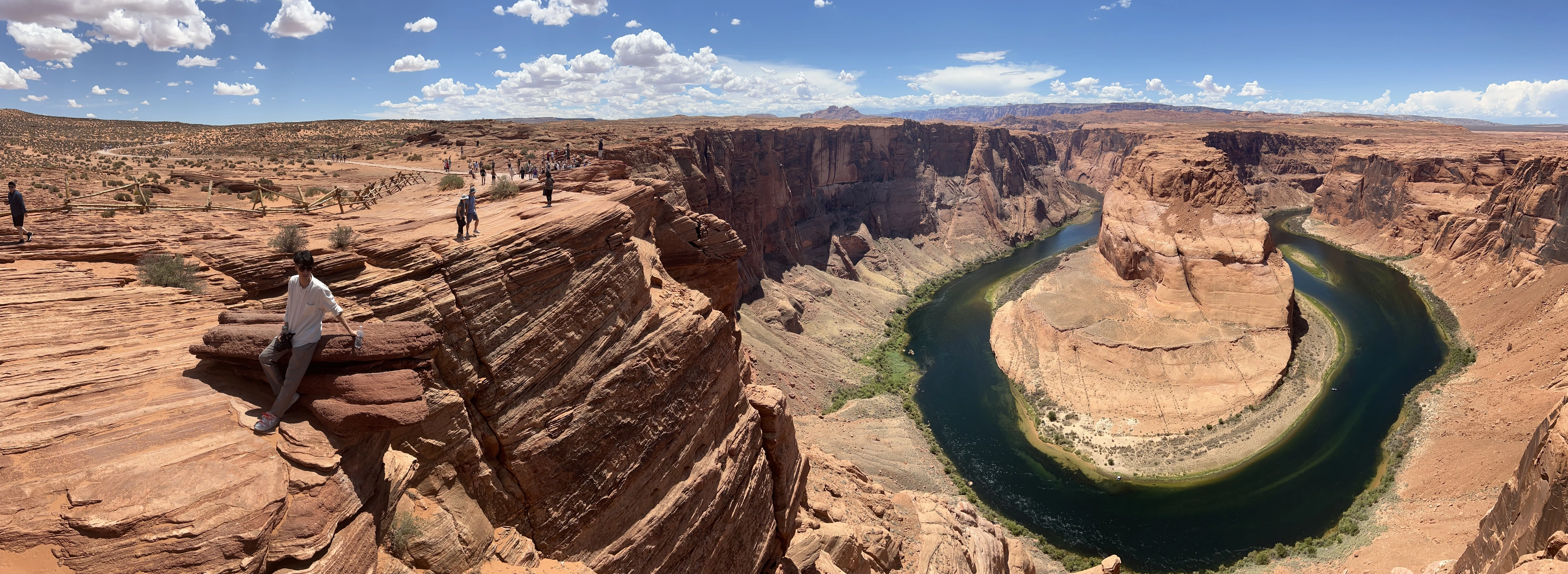 A panoramic view of Horseshoe Bend beneath a bright desert sky