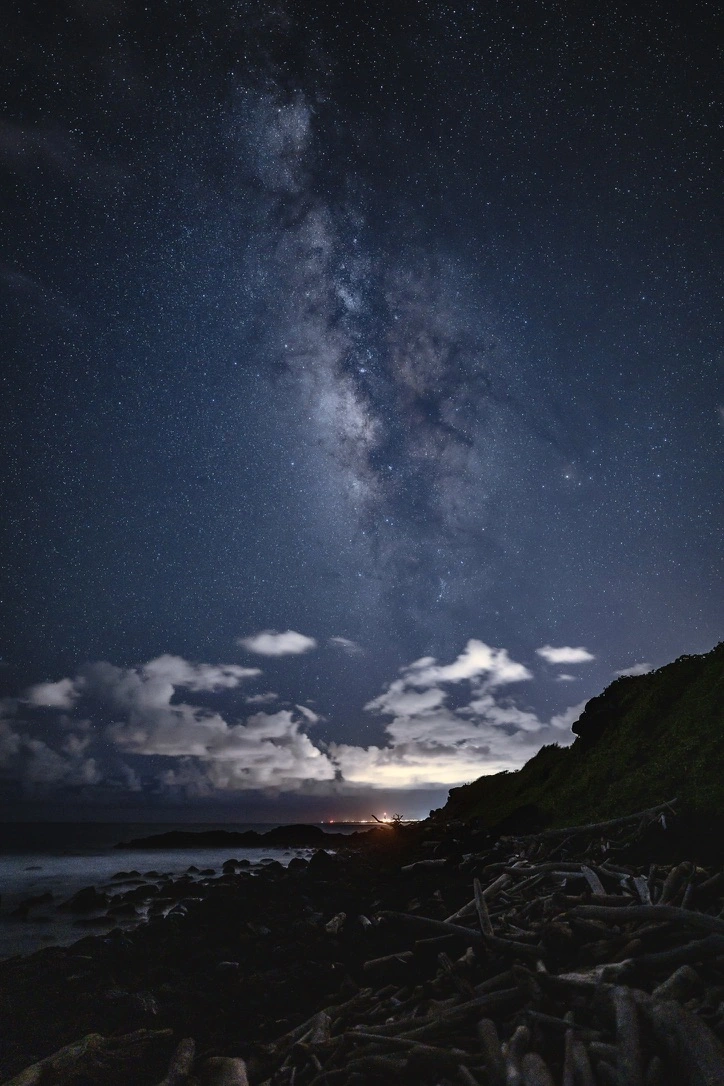 The Milky Way rising vertically above a dark Kapaʻa coast