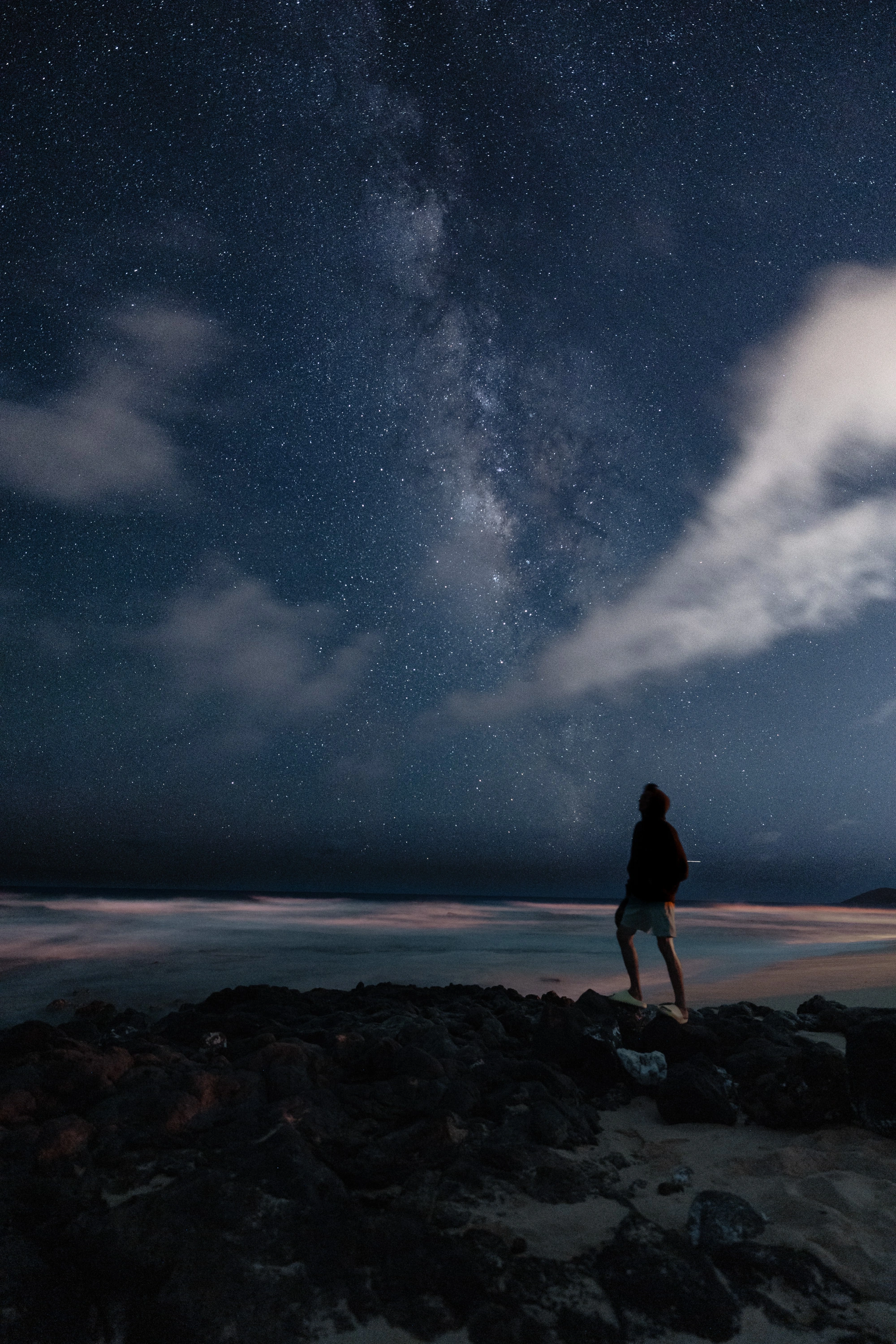 A solitary figure standing beneath the Milky Way