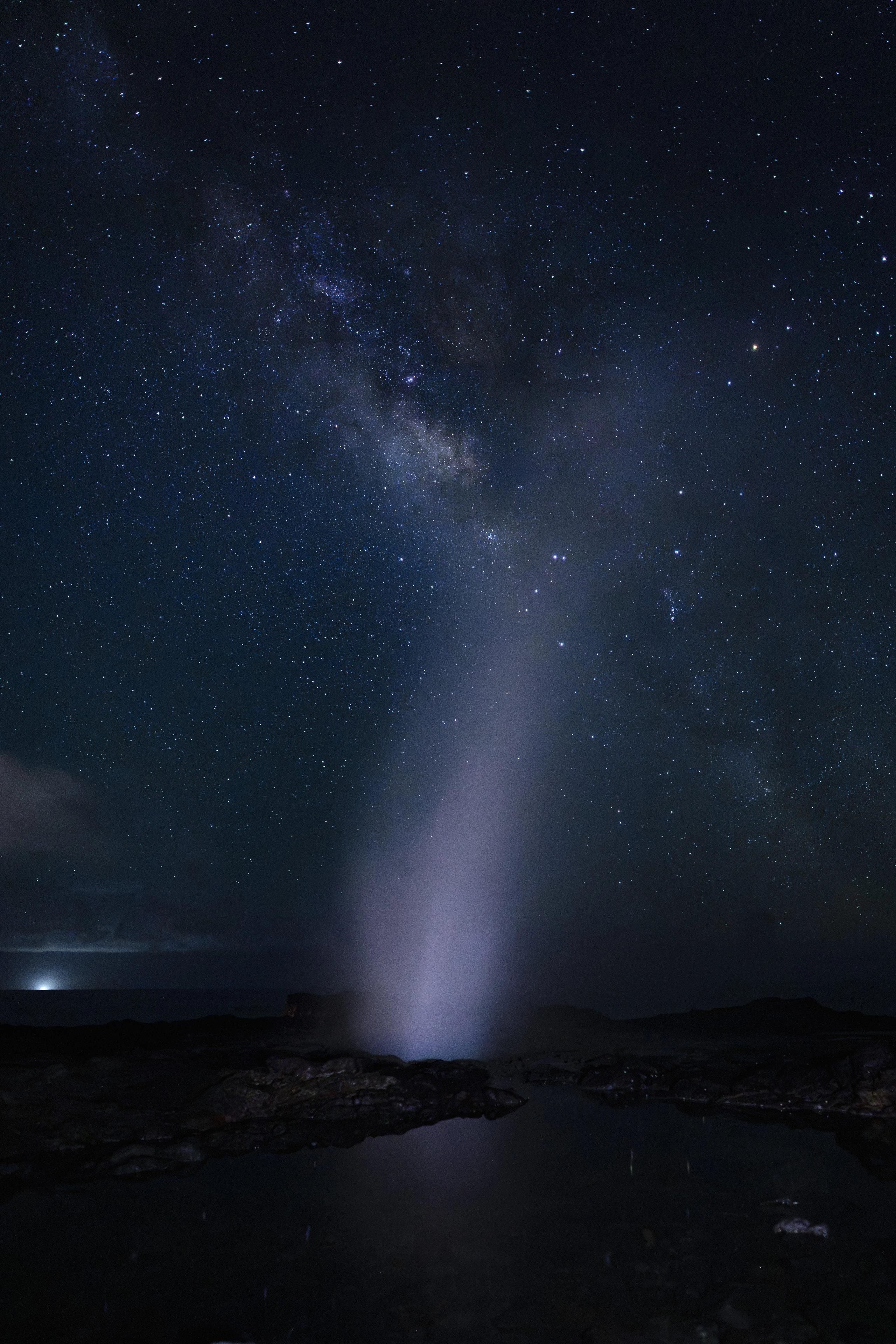 A softly illuminated plume from Spouting Horn beneath the Milky Way
