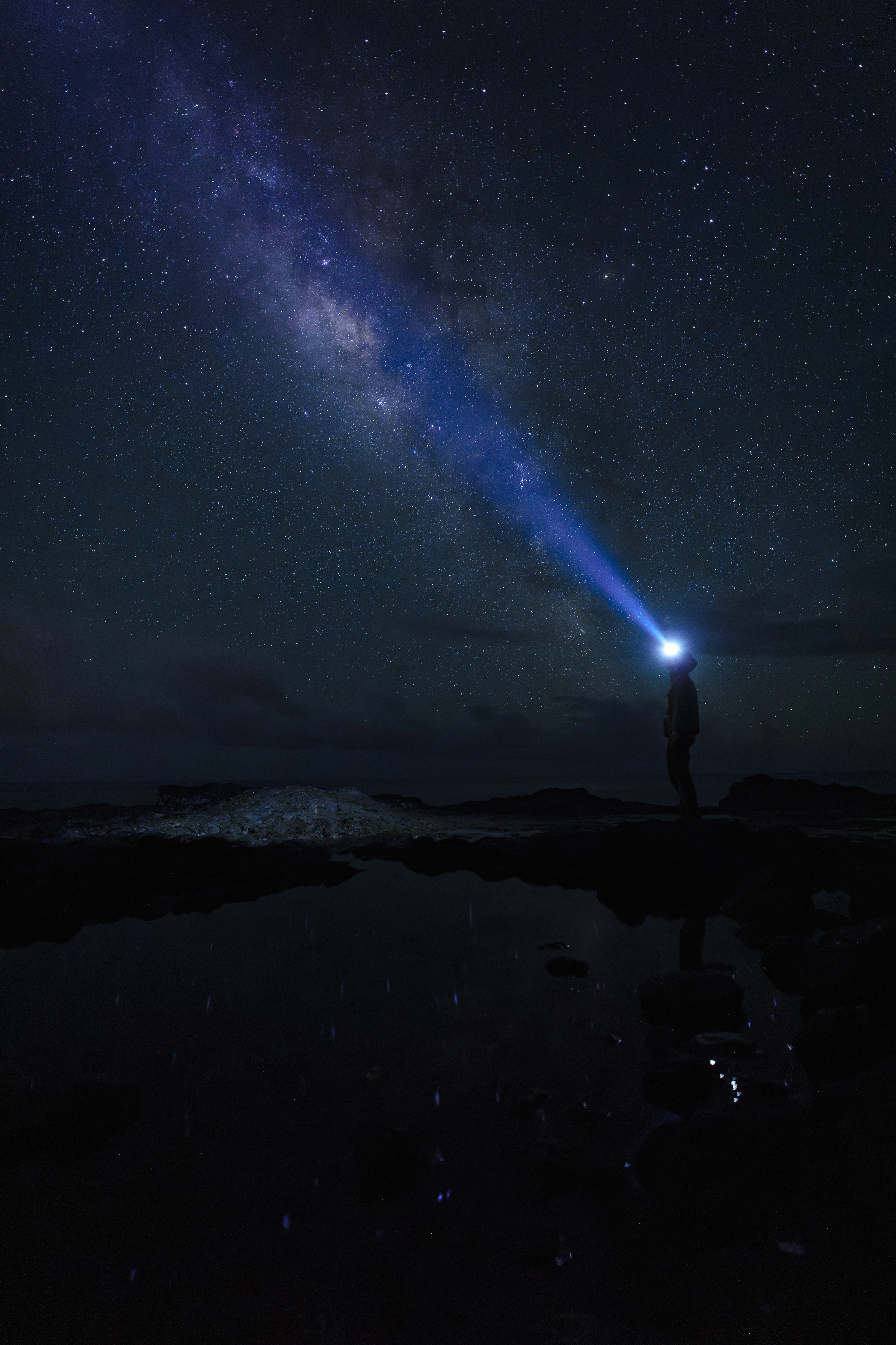 A narrow beam of phone light beneath the Milky Way at Spouting Horn
