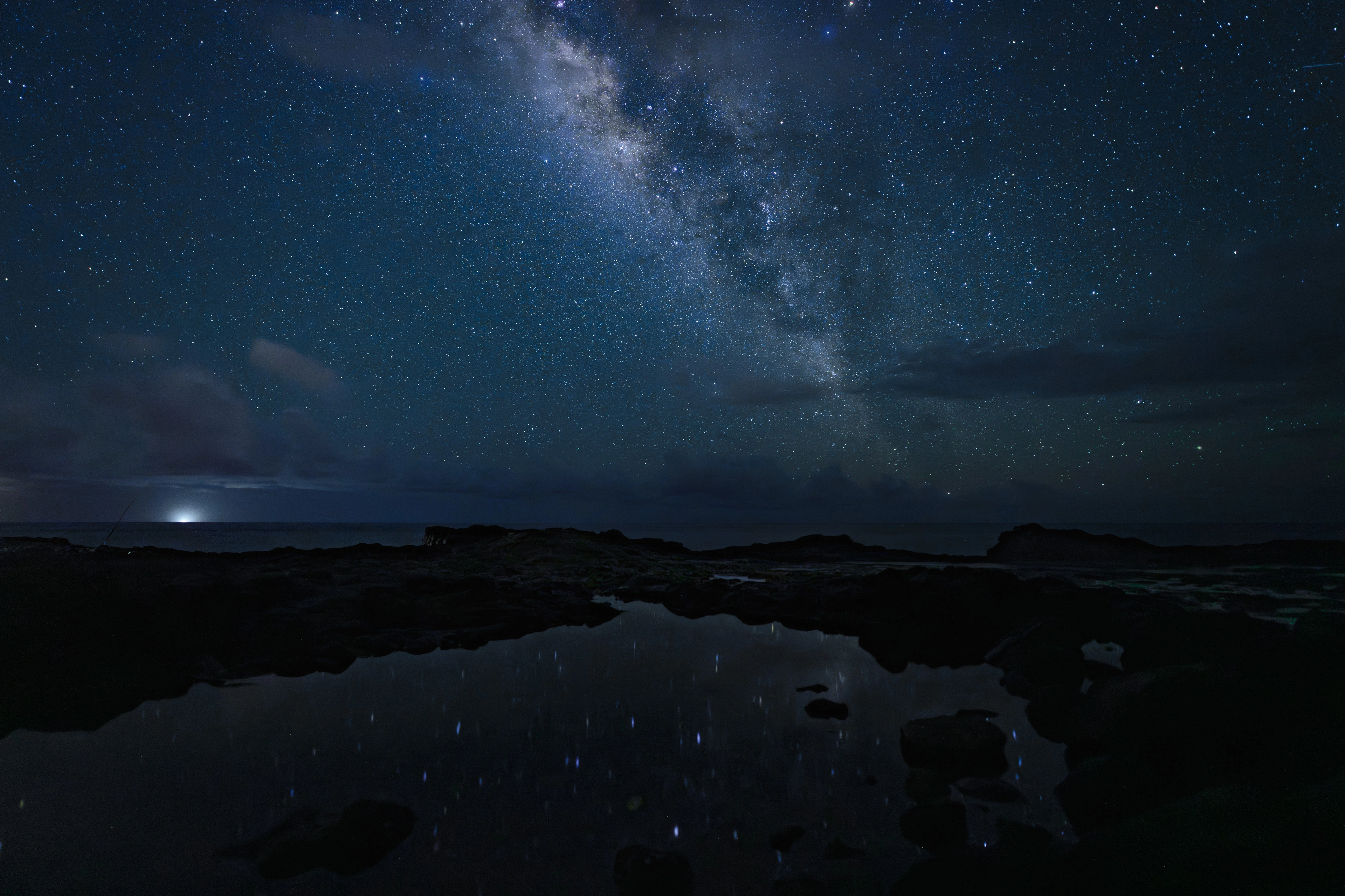 A wide view of the Milky Way and a tide pool at Spouting Horn