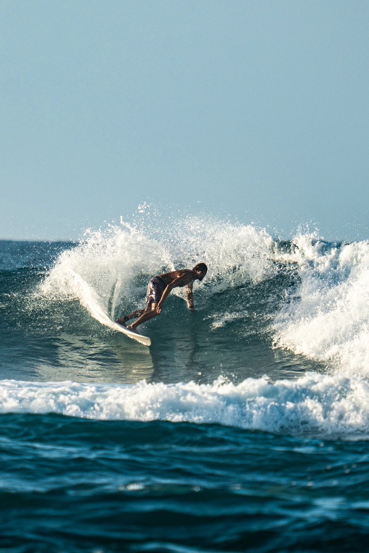 A surfer carving a turn through white spray
