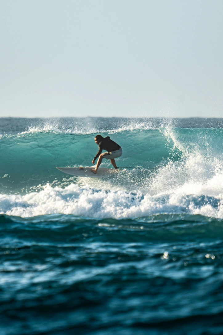 A surfer holding a clean line across a turquoise wave