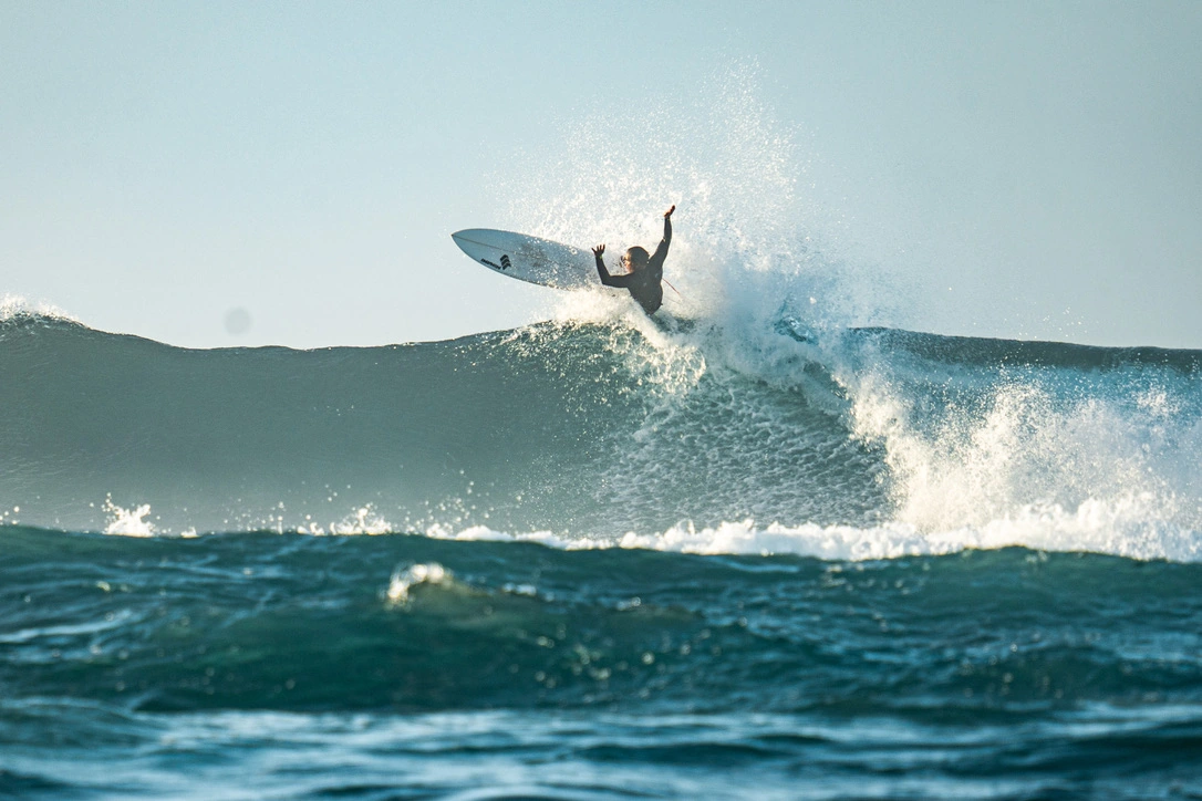A surfer rising above the lip of a breaking wave