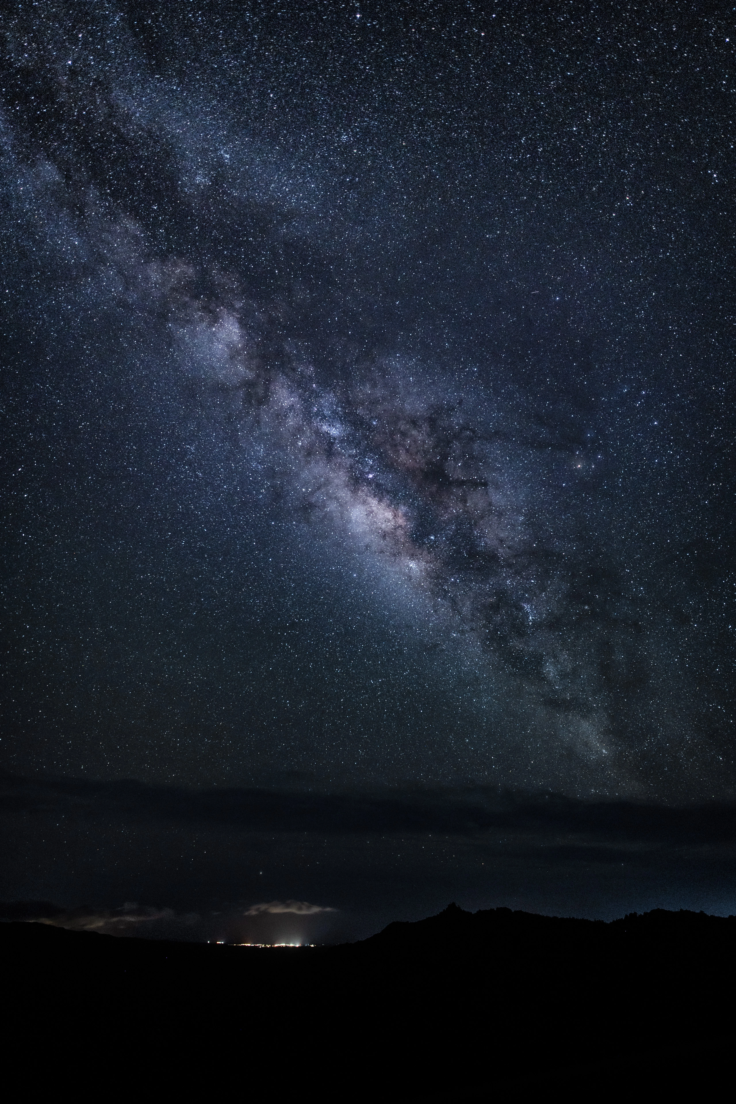 The Milky Way above distant island lights seen from Waimea Canyon