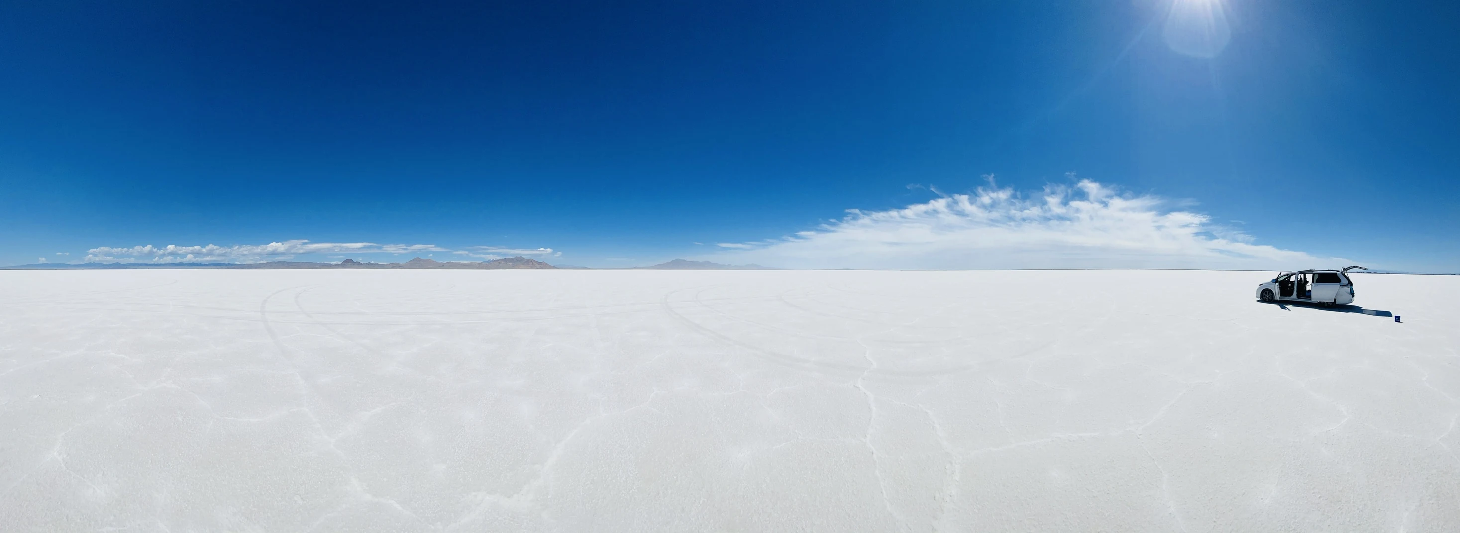 A panoramic view of a white van on the Bonneville Salt Flats