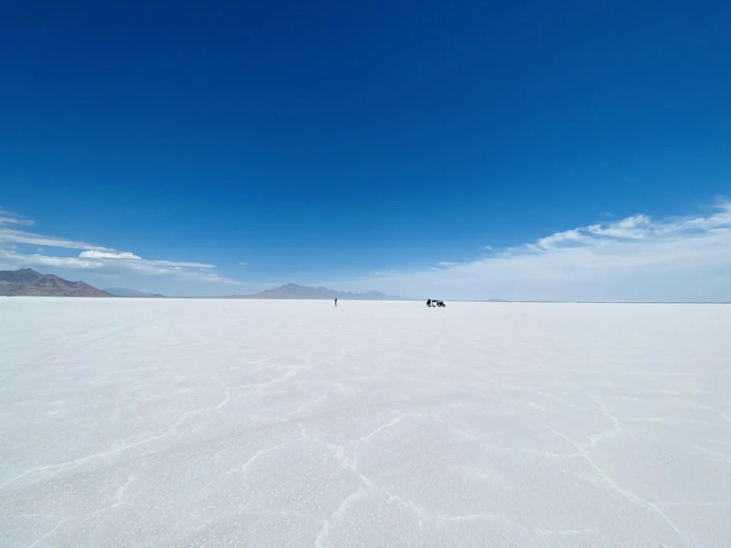Small figures and a van on the wide white Bonneville Salt Flats
